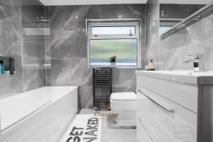 a bathroom with a sink and a toilet and a window at Stag & Stay- Waterlillie - Contractor friendly, Fast WiFi in Port Glasgow +18 photos