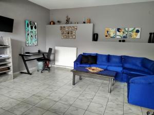 a living room with a blue couch and a table at Karel house in Karés