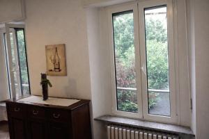 a room with two windows and a wooden dresser at Milano in Saronno