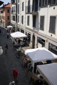 an outdoor market with white umbrellas on a street at Milano in Saronno