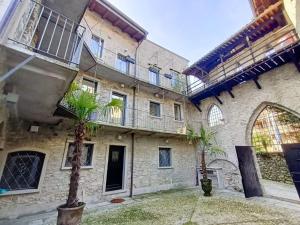 a building with two palm trees in the courtyard at Lago Lounge & Pool in Stresa
