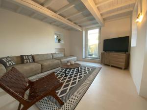 a living room with a couch and a tv at Lago Lounge & Pool in Stresa