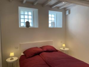 a bedroom with a red bed and two windows at Lago Lounge & Pool in Stresa +15 photos