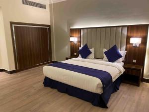 a large bed in a hotel room with blue pillows at بيست ليفل للشقق المخدومة in Al Khobar +72 photos