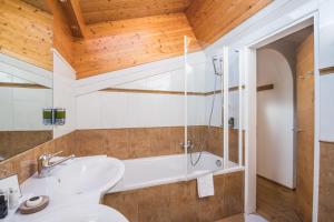 a bathroom with a toilet and a sink and a tub at Swiss Alpine Hotel Allalin in Zermatt +37 photos