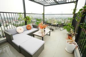 a patio with a couch and a table on a balcony at Hanoi Aurelia Stay in Hanoi