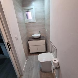 a small bathroom with a toilet and a sink at La calma de Aisheric in Nigrán