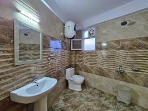 a bathroom with a sink and a toilet and a mirror at Newlands homestay near mall in Shimla +42 photos