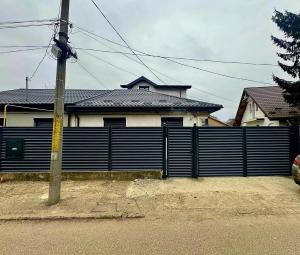 a fence in front of a house with a house at Cosy Vibe 2 in Vaslui
