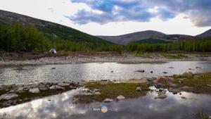 a river with a tent and mountains in the background at Shaanlda in Ongon