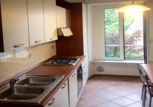 a kitchen with a sink and a stove and a window at Milano in Saronno