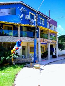 a blue building with a bird statue in front of it at Porto Pousada in Ipojuca