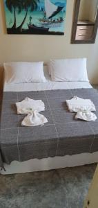 a bedroom with a bed with towels on it at Porto Pousada in Ipojuca