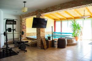 a living room with a flat screen tv and a brick wall at AB Holiday Home in Siófok