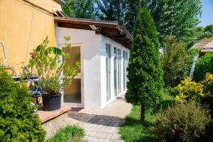a garden entrance to a house with trees and plants at AB Holiday Home in Siófok