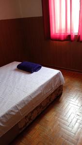 a bed sitting in a room with red windows at Pausada Regis in Lavras