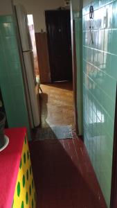a kitchen with green tiled walls and a red counter top at Pausada Regis in Lavras
