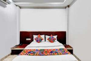 a bed with colorful pillows in a room at FabHotel P2 And Resort in Bhopal