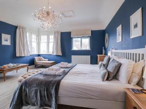 a bedroom with a large bed with blue walls at Holly Lodge in Aldeburgh