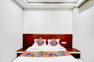 a bed with colorful pillows in a room at FabHotel P2 And Resort in Bhopal +22 photos