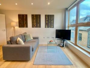 a living room with a couch and a flat screen tv at Your Space Apartments - Cambridge Place in Cambridge +2 photos