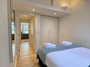 a bedroom with a bed with towels on it at Your Space Apartments - Cambridge Place in Cambridge