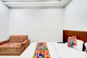 a bedroom with a bed and a chair at FabHotel P2 And Resort in Bhopal