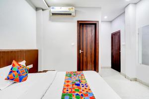 a bedroom with a bed with a colorful blanket at FabHotel P2 And Resort in Bhopal
