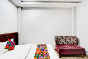 a bedroom with a bed and a chair at FabHotel P2 And Resort in Bhopal