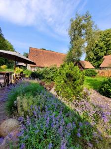 a garden with purple flowers and a picnic table at Nordenholzer Hofhotel in Hude