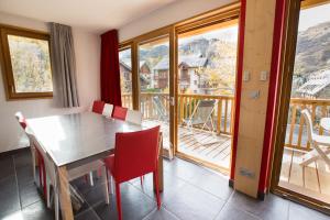a dining room with a table and chairs and a balcony at Les Sabots d'Hélène in Valloire