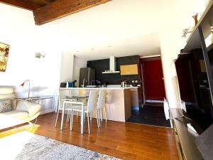 a kitchen and living room with a table and chairs at Apartament 5 persones Llar de Foc i Piscina in Saillagouse