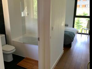 a bathroom with a tub and a toilet and a bed at Apartament 5 persones Llar de Foc i Piscina in Saillagouse +16 photos