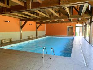 a large indoor swimming pool with blue water at Apartament 5 persones Llar de Foc i Piscina in Saillagouse