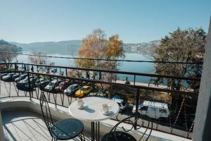 a balcony with a table and chairs and a view of a river at CASA BIANCA Kastoria in Kastoria