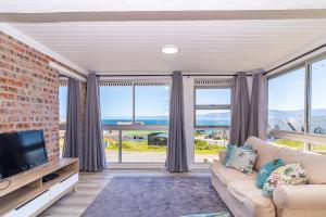 a living room with a couch and a tv at Whale Heights in De Kelders