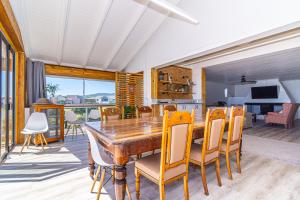 a dining room with a wooden table and chairs at Whale Heights in De Kelders