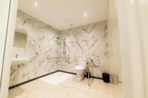 a bathroom with marble walls and a toilet and a sink at ESTRELA DO CAMIÑO in Palas de Rei