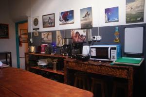 a kitchen with a counter with a computer on it at Rancho Lamaral Hostel & Camping in Rodeo +74 photos