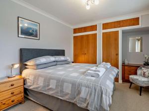 a bedroom with a bed with a dresser and a chair at 2 Bed in Killin oc-pe512 in Killin
