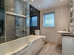 a bathroom with a tub and a toilet and a sink at 2 Bed in Killin oc-pe512 in Killin +11 photos