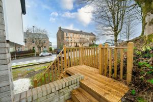 a wooden bench sitting next to a wooden fence at Stag & Stay- Waterlillie - Contractor friendly, Fast WiFi in Port Glasgow