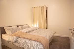 a bedroom with a bed and a window with a curtain at Flat 2 Aylesbury Street in Bletchley