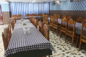 a dining room with two tables and chairs and a table and chairs at Siachen Hotel in Kargil