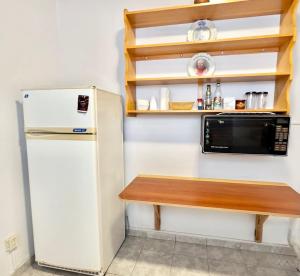 a small kitchen with a microwave and a refrigerator at Betania in Carhué