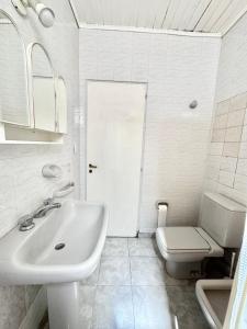 a white bathroom with a toilet and a sink at Betania in Carhué