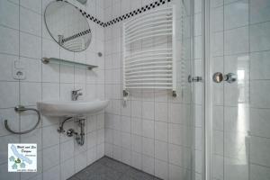 a bathroom with a sink and a shower with a mirror at Wald und See Dargun 16b in Dargun