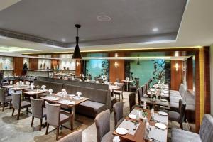 a restaurant with tables and chairs and a bar at Lavender Premier in Bangalore