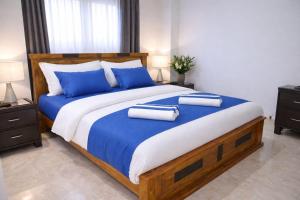 a bedroom with a large bed with blue pillows at Kandy Royal Resort in Kandy