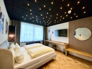 a bedroom with a bed and a desk and a television at Hotel Credé in Kassel +105 photos